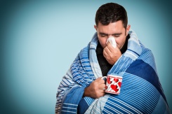 Photo of a man sneezing.