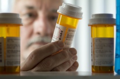 an older man looking at a pill bottle